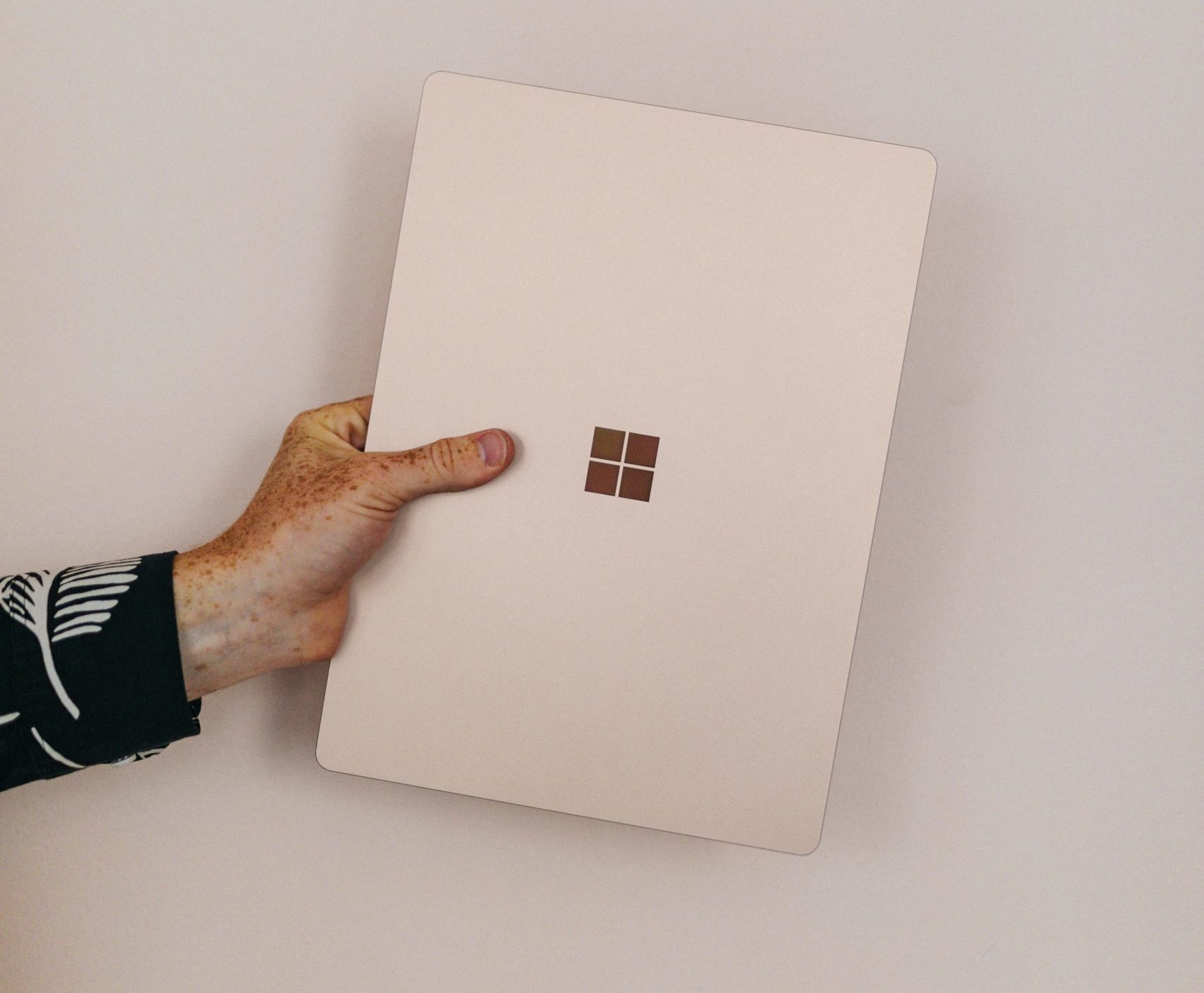 gnlvxxs4ehq scaled e1589525047785 person holding sandstone microsoft Surface laptop laptop